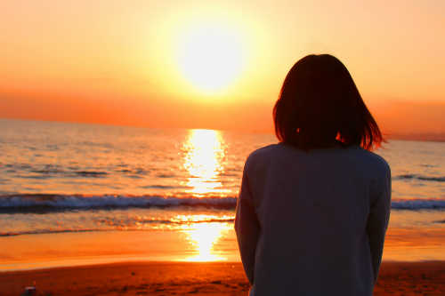 夕陽をながめる女性の画像