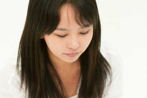 穏やかな表情で目をつぶる女性の画像