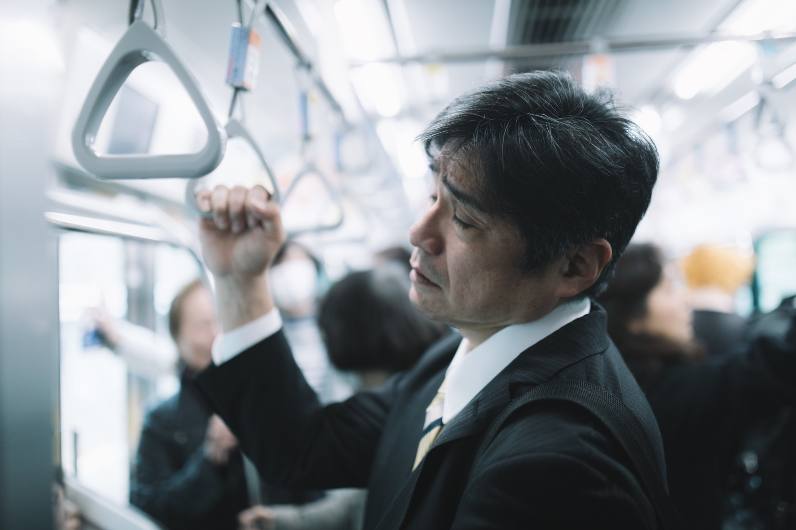 電車の中で肩を落とすサラリーマン