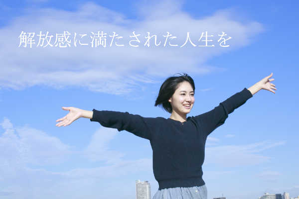 青空のもとで女性が手を広げている画像