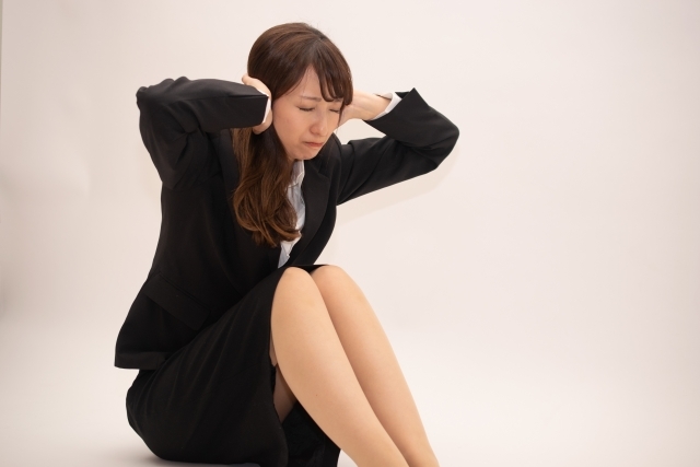 耳をふさぐ女性