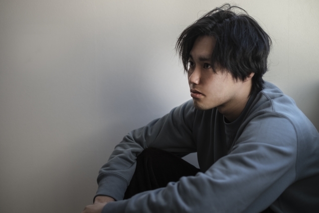 呆然と一点を見つめる若い男性