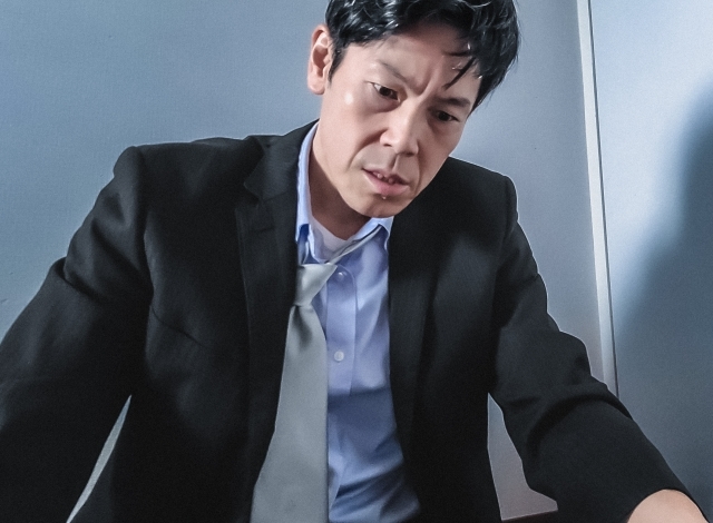 なぜだ？と苦悶の表情で歯を食いしばる中年男性
