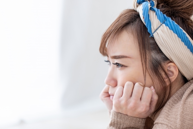 自室で怒りのつのらせる女性の画像