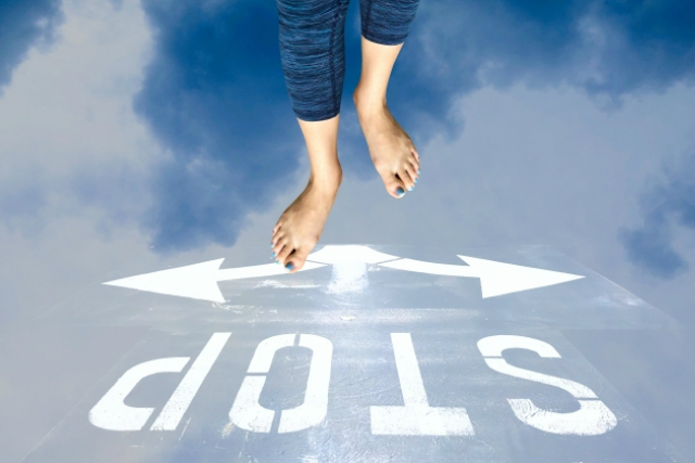 分かれ道で立ち止まる裸足の足