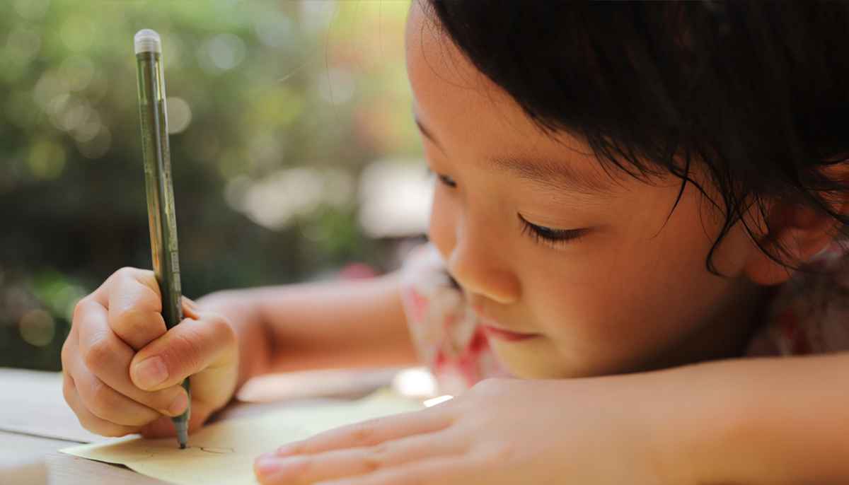 一生懸命手紙を書く幼い女の子