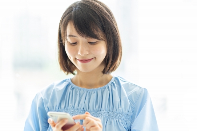 スマホを見て微笑む女性